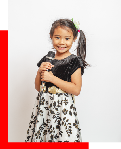 Young child holding a microphone during kids music lessons in Duarte, CA, building confidence and performance skills